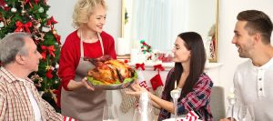 Happy family having Christmas dinner in living room